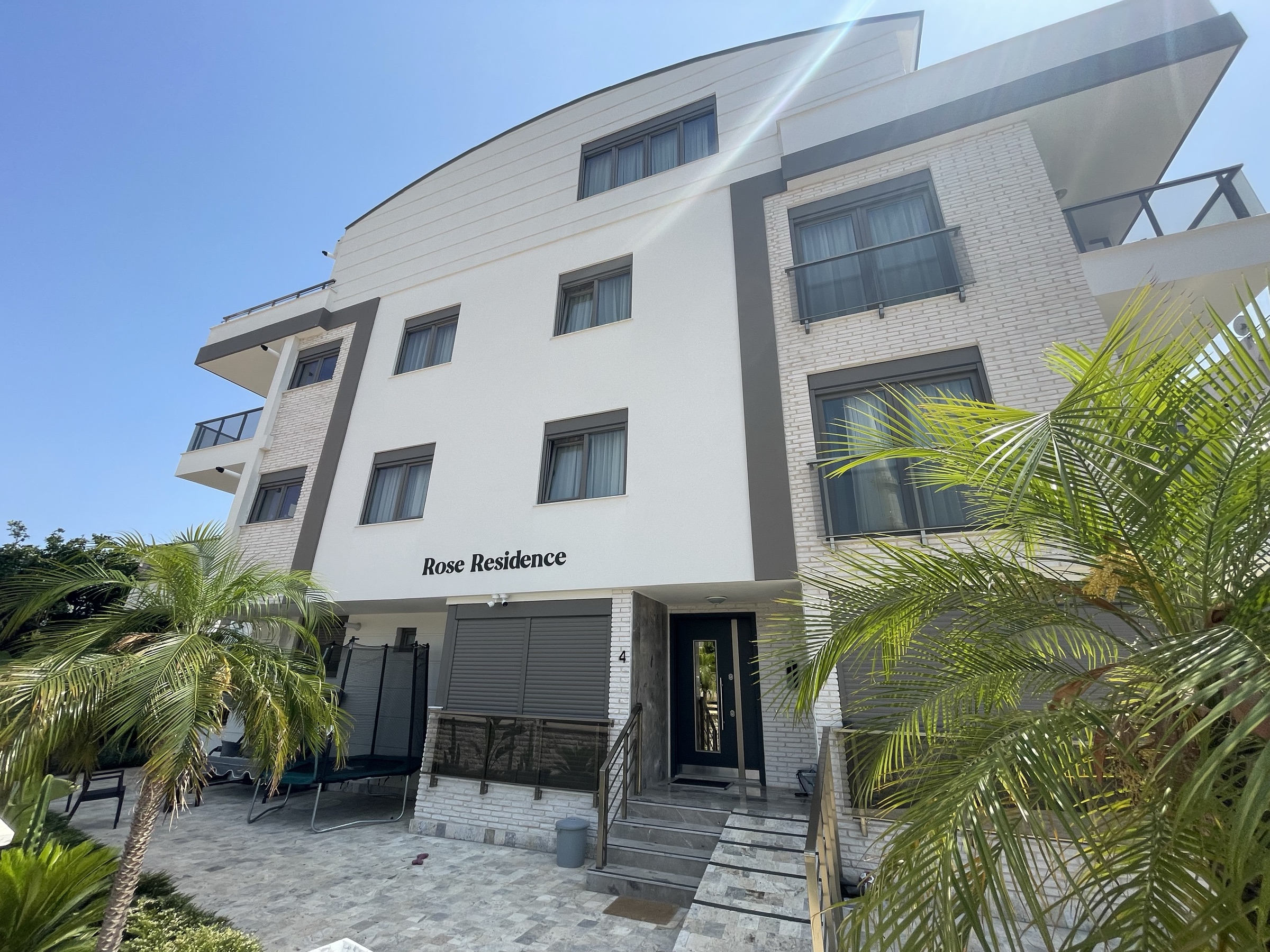 The Rose Residence building with its palm trees and entrance
